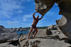Urso musculoso catalo nas rochas da praia